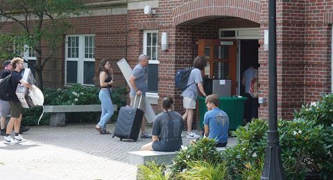 Photo of people moving items into a residence hall building