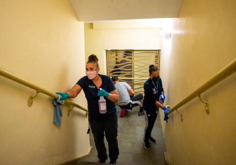 Housekeeper cleaning by the rails