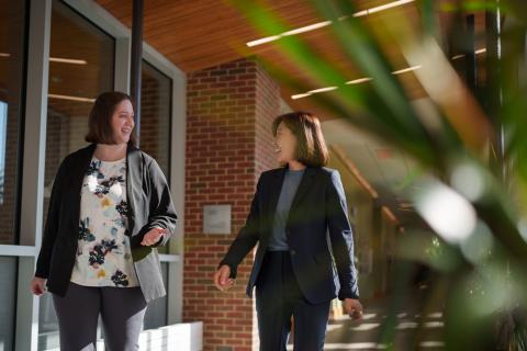 two women walking on campus