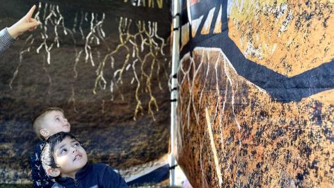 preschool students sit in the Earth Around Us soil tent and observe the artwork on the tent walls