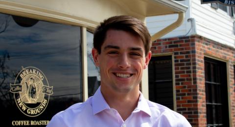 Student standing in front of Breaking New Grounds coffee shop