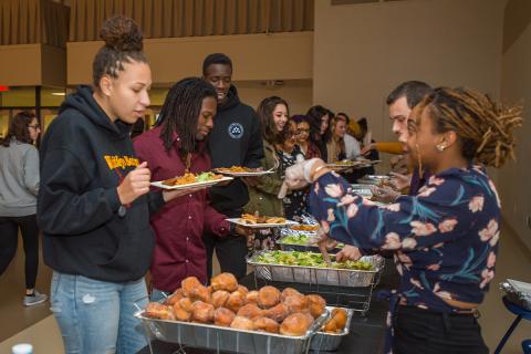 Students taking food at the Latinx Dinner