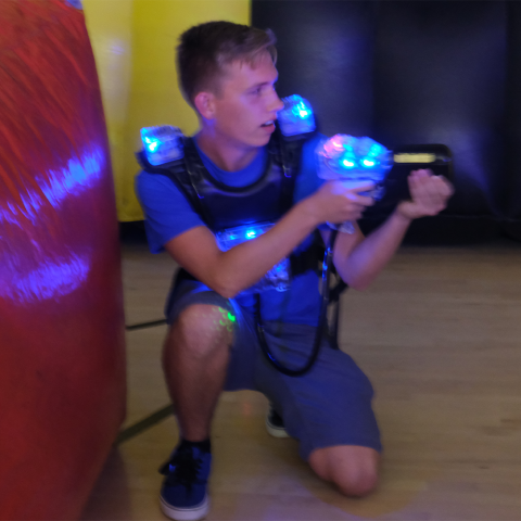 Student crouching playing laser tag