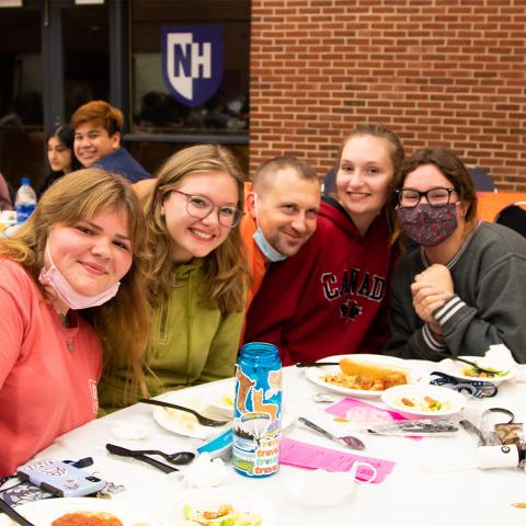 Students posing with Murder Mystery actor and dinner