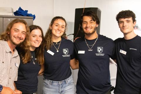 Five MUB employees wearing MUB t-shirts posing together