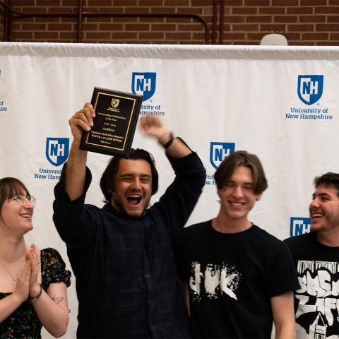 Student org holding up award plaque.