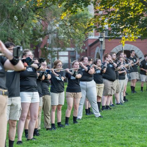 UNH band lined up playing instruments outside.