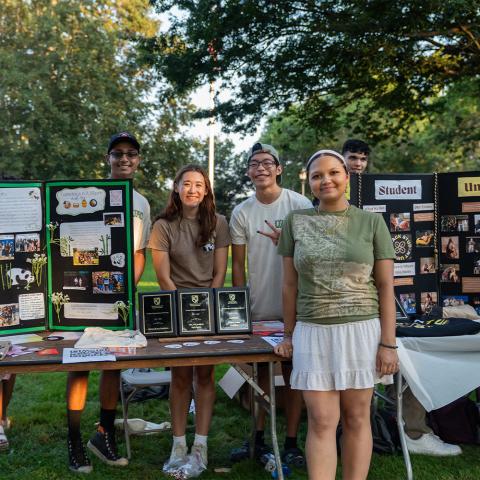 Members of student orgs posing in front of their tables.