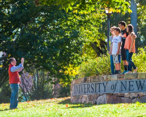 Family posing for picture on UNH campus
