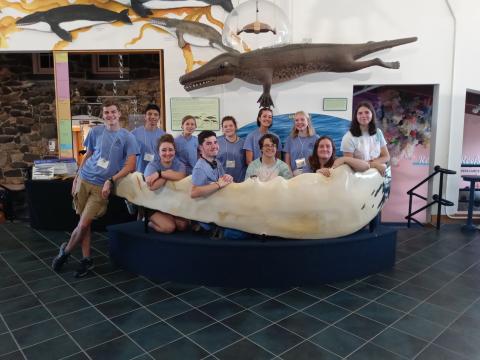 Students posing in a shark jaw