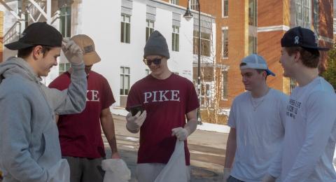 A group of men holding trash bags