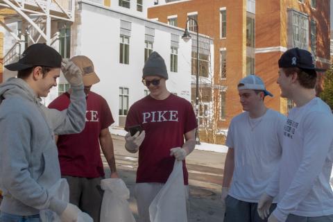 A group of men holding trash bags