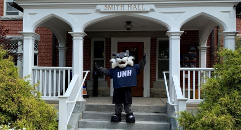 WildEcat waving in front of Smith Hall