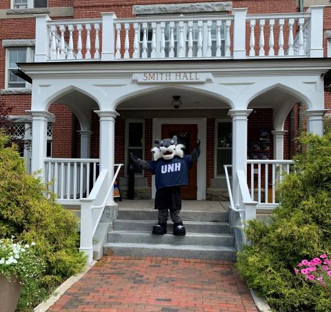 WildEcat waving in front of Smith Hall