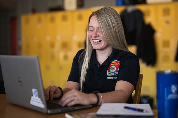 Kayleigh Eastman on laptop in fire station