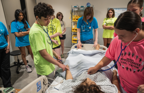 High school students practice on a mannequin at the UNH Health Sciences Simulation Center