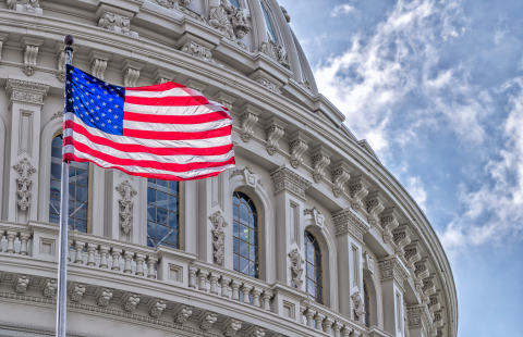 Stock photo of the American flag in front of the US Capitol building