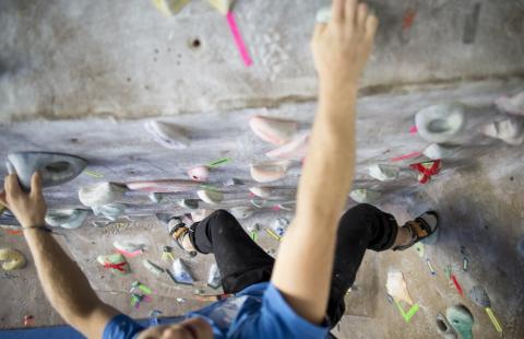 Rock climber shot from above at an indoor rock wall