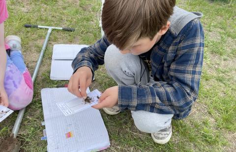 Elementary school student examines soil as part of Earth Around Us tent program.