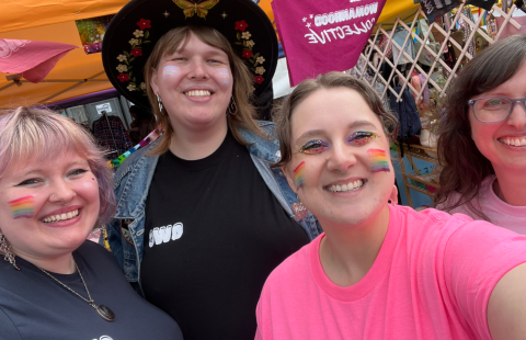 Four individuals taking a selfie at a pride parade