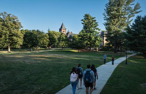 Students walk a concrete path on the UNH campus