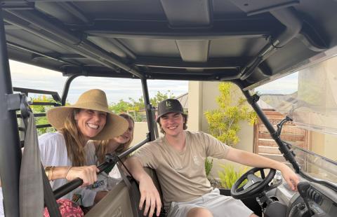 Landon Sprague sits behind the wheel of a utility vehicle with two resort guests during his internship at Lovango Resort & Beach Club.