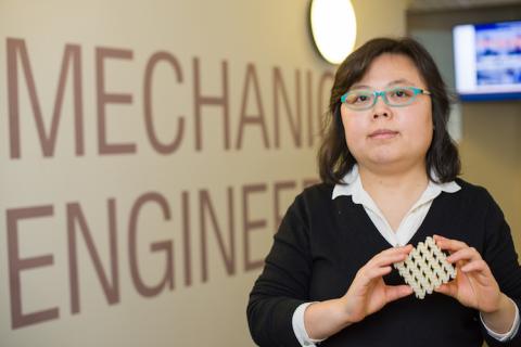 Mechanical engineering professor Yaning Li holding 3D printed square