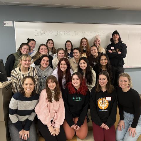 Group picture of SHARPP volunteers and staff in front of a whiteboard