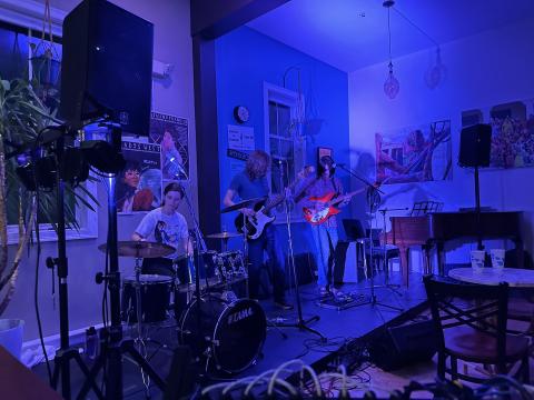 perform for freedom night at the freedom cafe, band on stage with dim lights