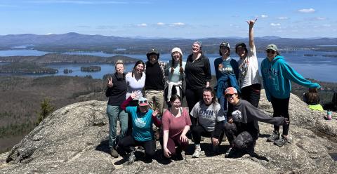 group of hikers smiling on a summit