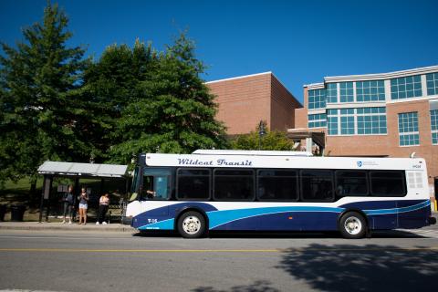 Picture of Wildcat Transit bus waiting at a bus stop outside of the Memorial Union Building.