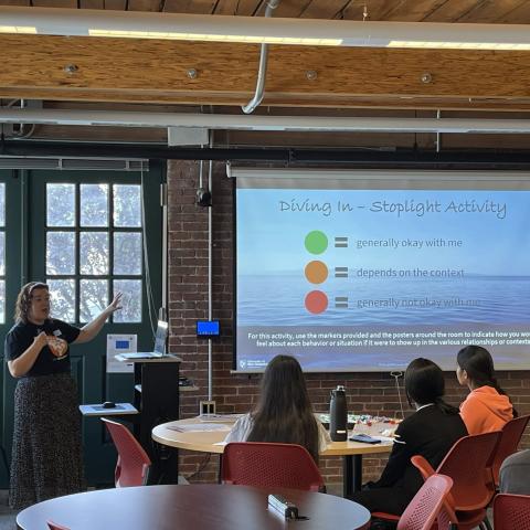 Picture of Caroline Young conducting a prevention program with students in the audience