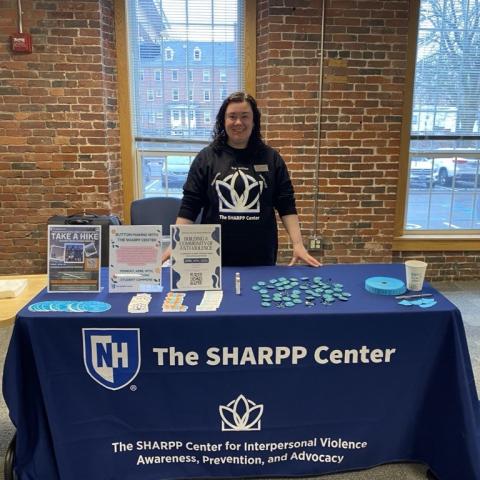 Picture of Caroline Young tabling at UNH Manchester with SHARPP Center outreach materials