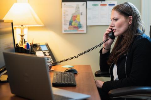 Picture of an advocate on the phone talking with a survivor while sitting at a desk
