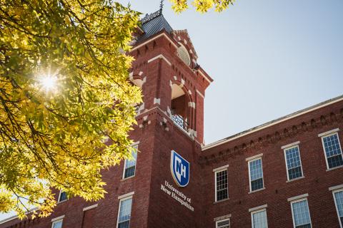 Picture of UNH Manchester's Building from the front with a tree on the side
