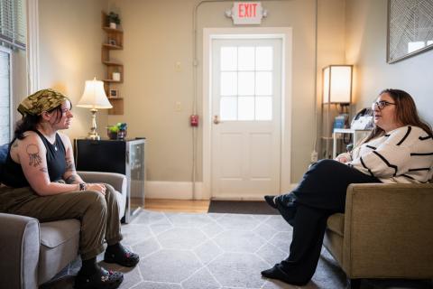Picture of an advocate talking with a survivor inside the advocate room at The SHARPP Center, they are sitting across from each other while in conversation