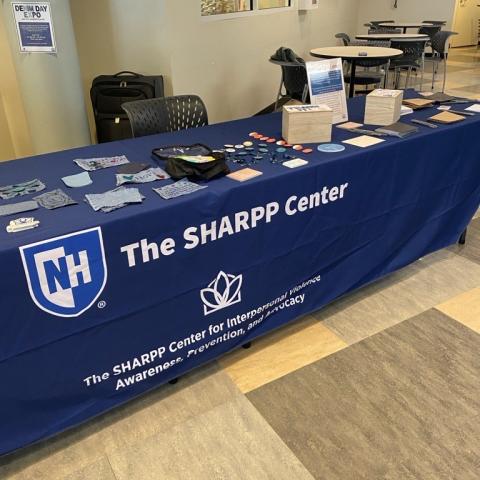 Picture of a SHARPP Center table set up with activities and outreach materials at the Law School
