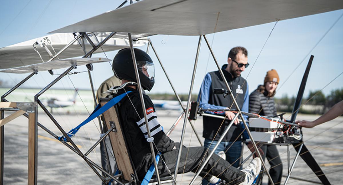 Male student in the cockpit of an ultralight aircraft designed by a team of UNH students