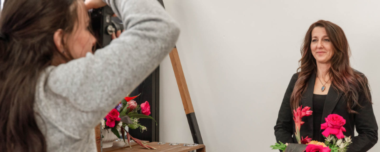Kayla Vine ’25 takes a photo of Karen McNeil, owner of Mode Salon and Wellness in Manchester. 