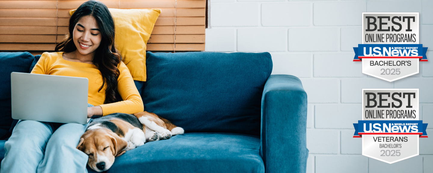a woman sitting on a couch next to a sleeping dog, using a laptop