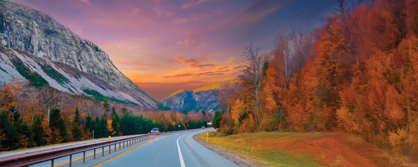 image of a road on the cliffside of a mountain surrounded by fall foliage