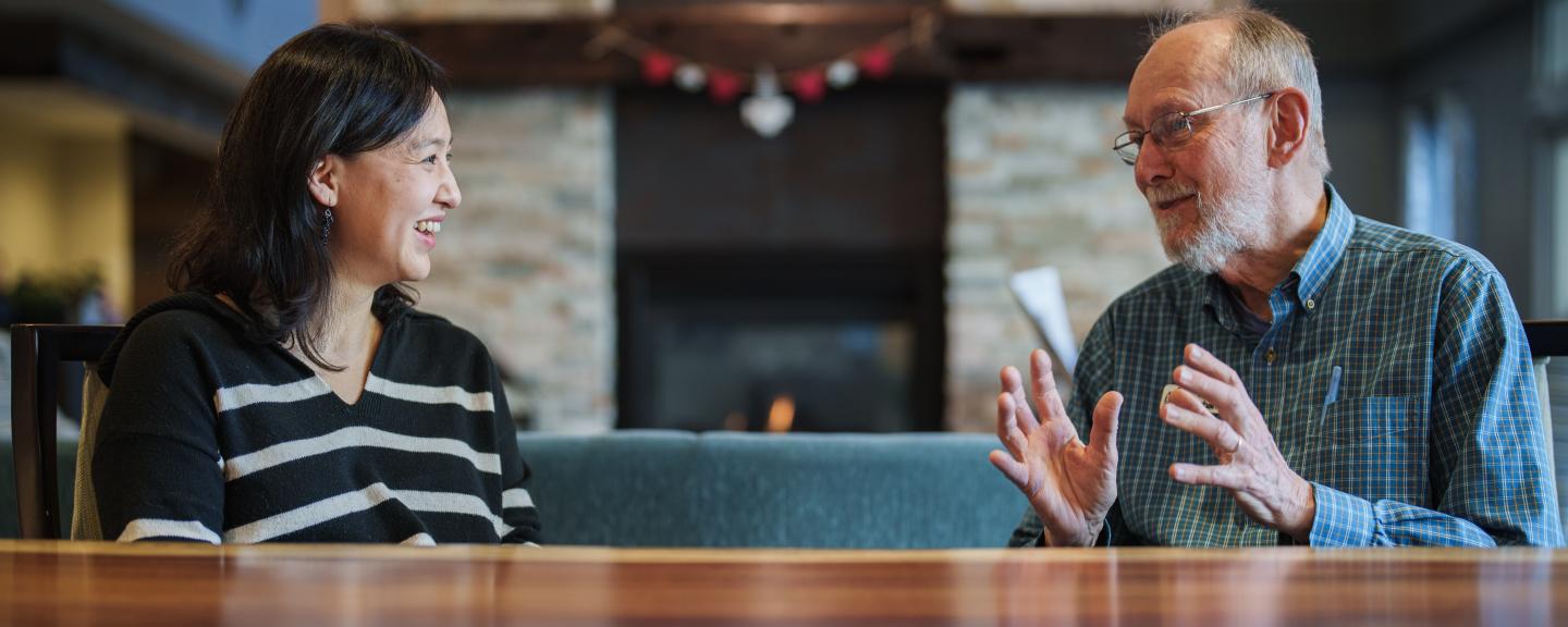 BoRin Kim, associate professor of social work, speaks with a resident at RiverWoods Durham