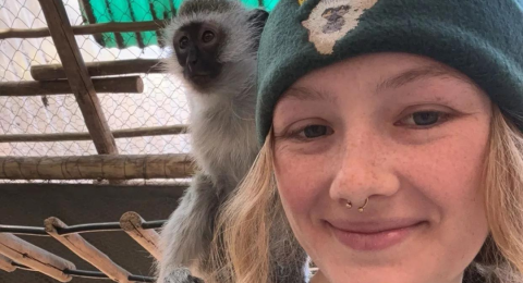UNH student Morgan Breen with monkey on her shoulder in South Africa where she is conducting research this summer.