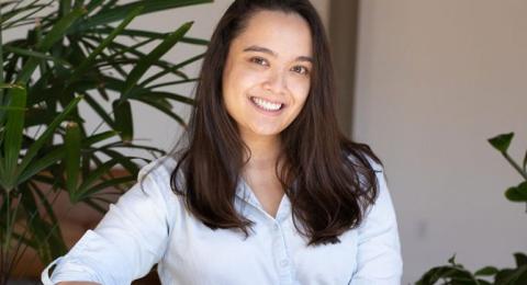 Woman in white blouse smiling at camera