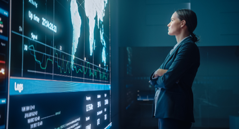 Woman in suit staring at a digital map of the world