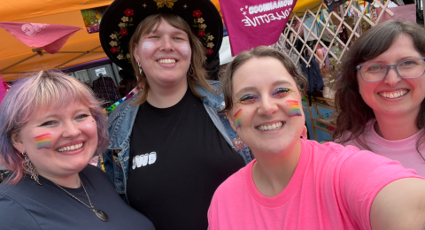 Four individuals taking a selfie at a pride parade