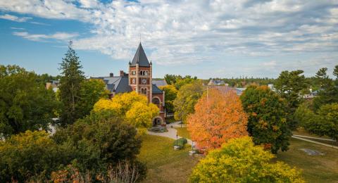 Aerial photo of UNH campus in fall, with bright trees in front of T Hall