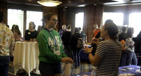 Two women engage in conversation in a convention center