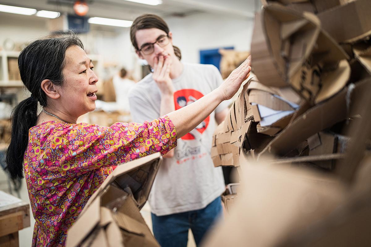 Professor Sachiko Akiyama talks to a student in her sculpture class