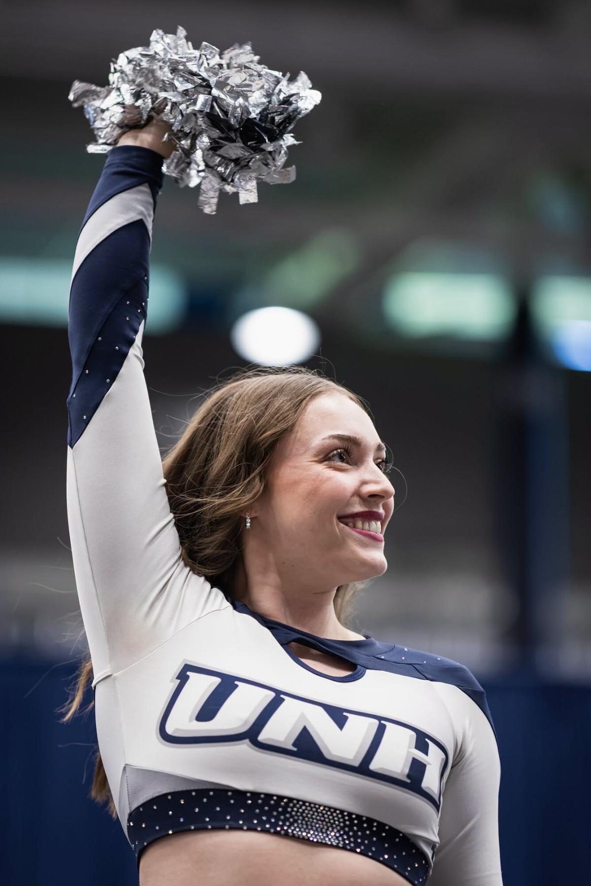 A UNH dancer waves a pom pom